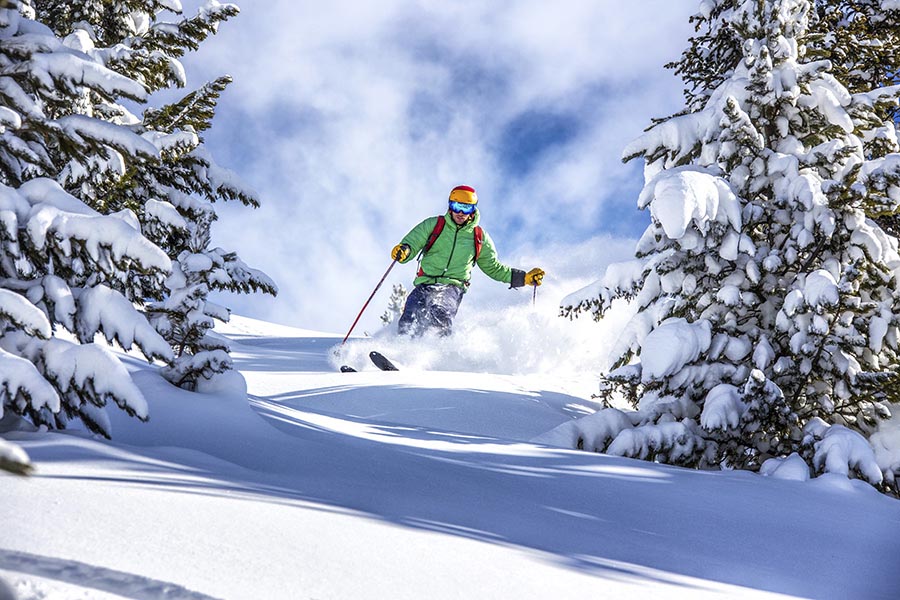 man skiing powder at sommet blanc deer valley